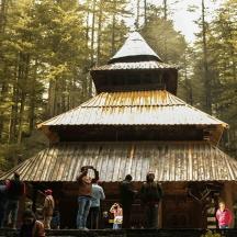 a group of people standing around a wooden building