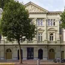 a large white building with a tree in front of it