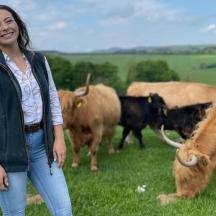 seorang wanita berdiri di padang dengan sekumpulan lembu