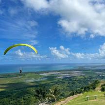 a person is flying a parachute over the ocean