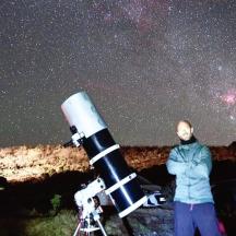un home dret davant d'un telescopi