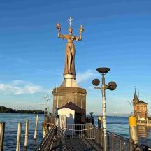 eine Statue einer Frau, die auf einem Pier steht