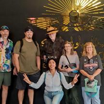 a group of people posing for a picture in front of a sun