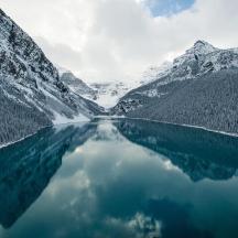 a body of water with snow covered mountains
