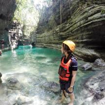 seorang lelaki berdiri di dalam kolam air di dalam sebuah gua