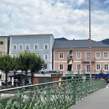 a bridge over a river with buildings and a statue
