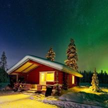 a cabin under the aurora in the woods