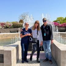 three people standing in front of a fountain