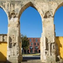 an old building with two arches in front of a building