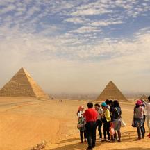 a group of people standing in front of the pyramids