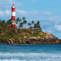 a red and white lighthouse on an island in the ocean