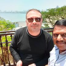 two men sitting next to each other on a balcony