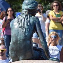 statua syreny przed tłumem ludzi