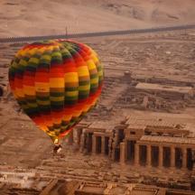 a colorful hot air balloon flying over a city