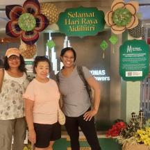 a group of three women standing in front of a store