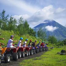 a group of people riding atvs on a dirt road