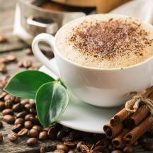 a cup of coffee on a plate with coffee beans