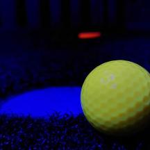 a green golf ball sitting on the ground