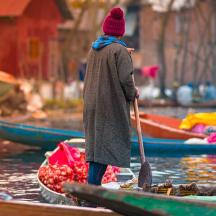 eine Frau steht mit einem Paddel auf einem Boot
