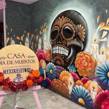 un murale di un teschio su un muro con fiori