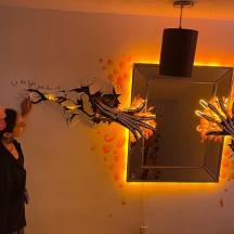 una donna sta dipingendo un muro con uno specchio