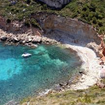 an aerial view of a beach with a boat in the water