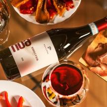 Una mesa con una botella de vino y platos de comida.