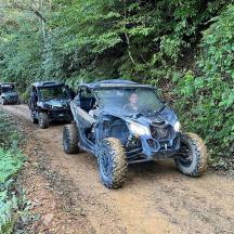 zwei Geländefahrzeuge auf einem Feldweg im Wald
