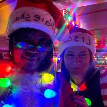 dua wanita memakai topi santa di dalam bilik dengan lampu