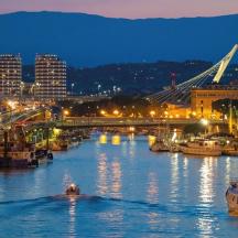ein Fluss mit Booten in einer Stadt bei Nacht
