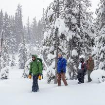 en gruppe mennesker som står i snøen