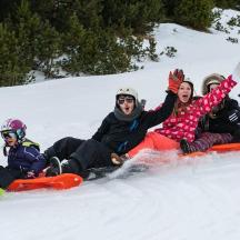 un gruppo di persone sedute sulla neve con gli snowboard