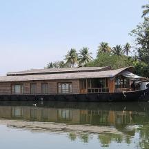a boat with a house on the side of a river