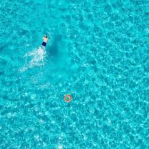 a group of people swimming in the blue water
