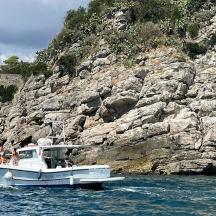 ein weißes Boot im Wasser in der Nähe einer felsigen Klippe