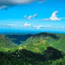 a view of a mountain with the ocean in the background