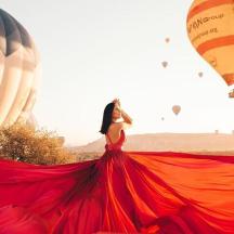 a woman in a red dress with hot air balloons