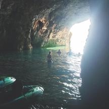 a group of people in the water in a cave