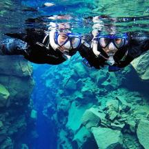 a person in a wetsuit and goggles swimming in the water
