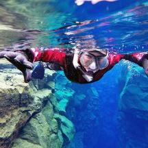 eine Person in einem Neoprenanzug, die im Wasser schwimmt