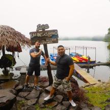 dua lelaki berdiri di sebelah papan tanda di sungai