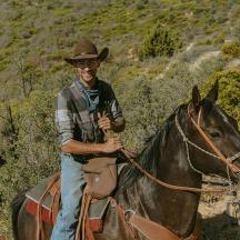 a man in a cowboy hat riding a horse