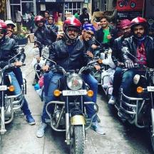a group of men riding motorcycles down a street
