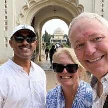 two men and a woman standing in front of a building