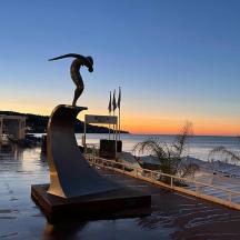 a statue of a bird on a surfboard in the water