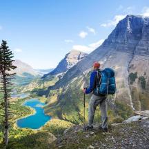 a man with a backpack standing on top of a mountain