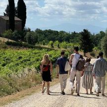 a group of people walking down a dirt road