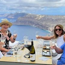 un grup de persones assegudes a una taula amb copes de vi