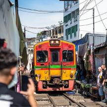 un tren vermell i groc que viatja per les vies amb gent