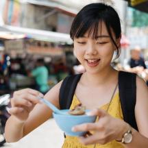 a woman eating a bowl of food with a spoon